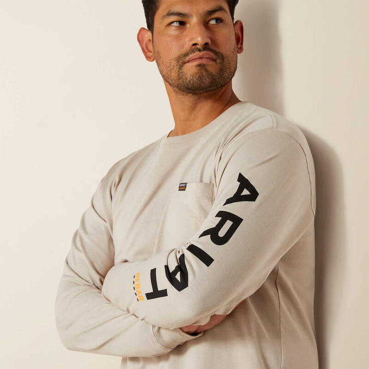 Detailed view of Ariat Rebar logo down the sleeve on beige t-shirt